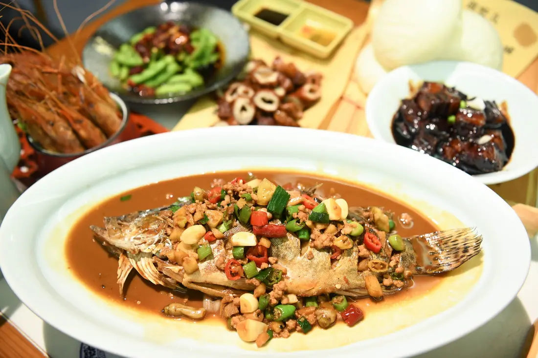 Finished braised stinky mandarin fish plated with other Anhui dishes
